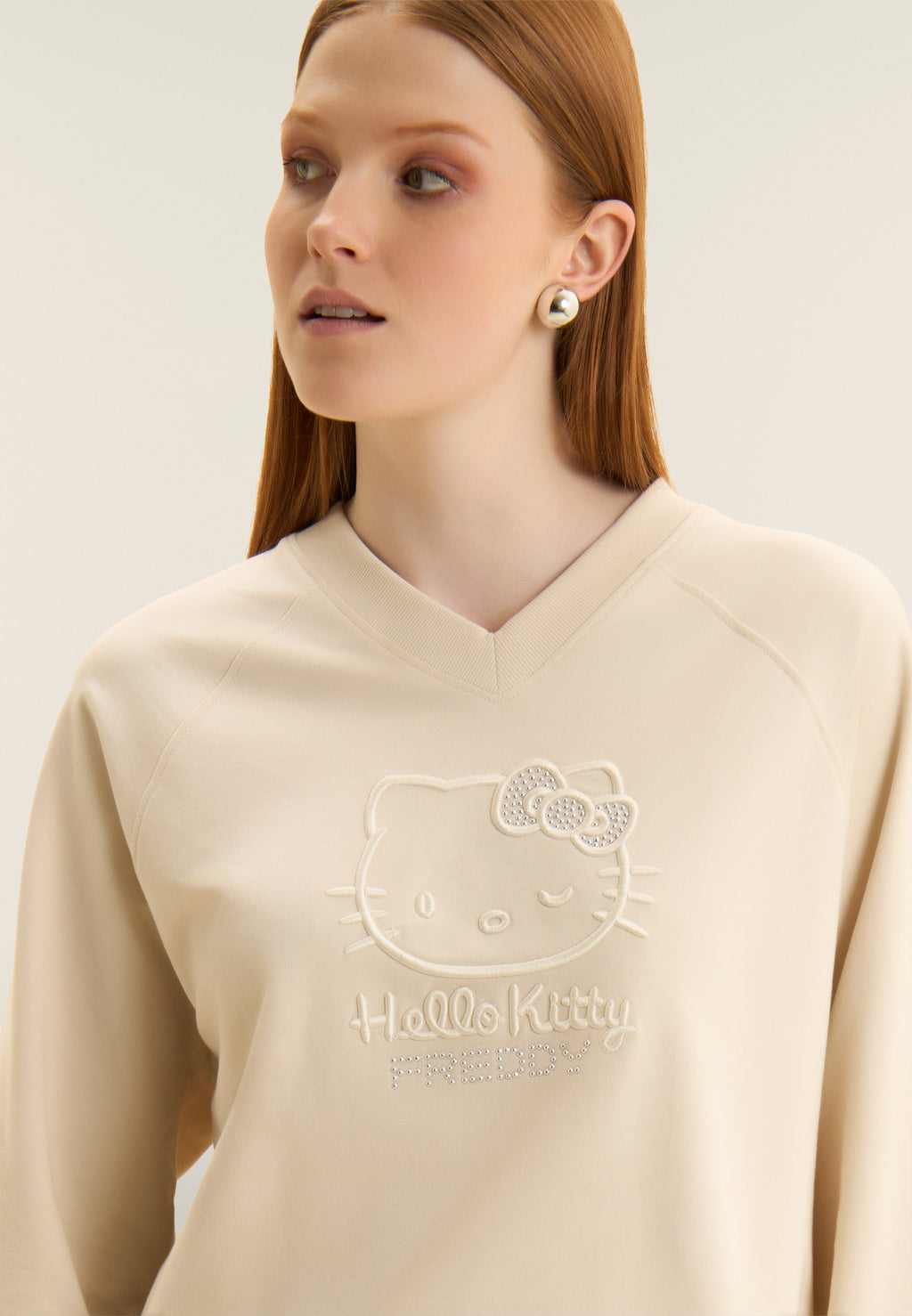 Zkrácená mikina s výstřihem do V a výšivkou Hello Kitty v béžové barvě